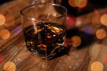a glass of whiskey on wood bar, soft focus.	