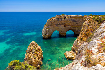 Natürliche Höhlen am Strand von Marinha, Algarve Portugal. Felsenklippenbögen am Strand von Marinha und türkisfarbenem Meerwasser an der Küste Portugals in der Algarve.