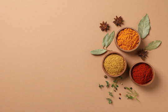 Bowls with different powder spices on craft background, space for text © Atlas