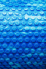 Abstract texture of a blue massage roller in the form of blue hexagonal cells. The entire screen as the background.