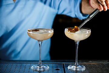 The bartender prepares a cocktail on the bar.
