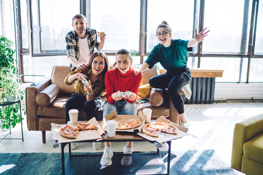 Joyful Friends On Couch Eating Pizza And Playing Video Game