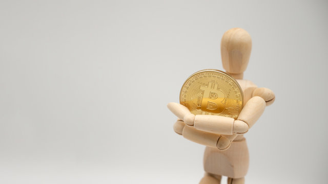 Gliederpuppe h&auml;lt Bitcoin BTC M&uuml;nze quer links