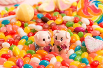 Fototapeta na wymiar A pair of piggy dolls in many candies