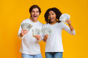 Happy couple holding lot of dollar cash in hands, rejoicing success © Prostock-studio