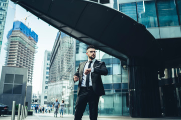 Fototapeta premium Businessman checking wrist watch on street