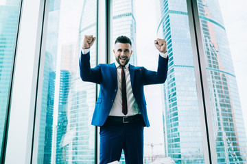 Excited businessman celebrating victory in office