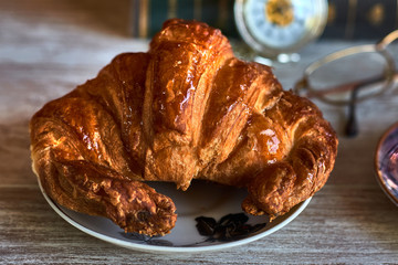 Classic breakfast with juicy croissant on a white plate