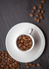 Coffee Beans in a Cup on Grey Black Background Top View Natural Light Selective Focus.