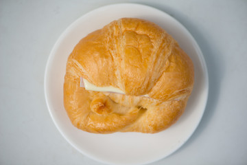 Closed up Croissant with cheese on white dish