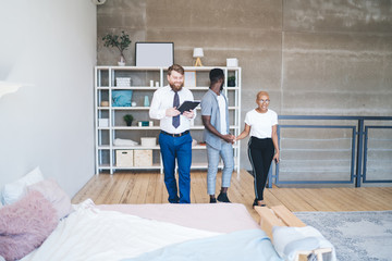 Positive real estate agent showing bedroom to black excited couple