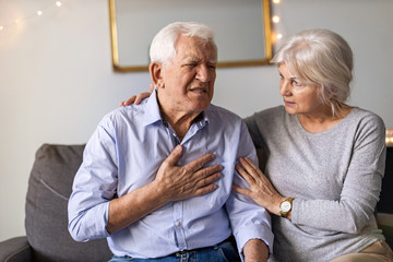 Senior woman helping her husband with chest pain