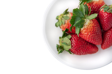 A lot of strawberry are in a white plate isolated on white background