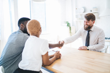 Ethnic couple making deal with estate agent