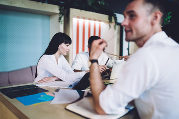 Obraz premium Friendly multiracial colleagues discussing project and surfing laptop during meeting