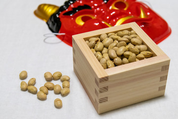 マス入りの節分福豆の奥に鬼のお面