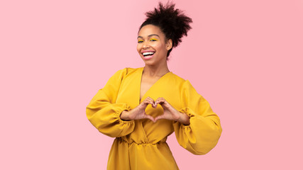 Smiling african american girl showing heart gesture