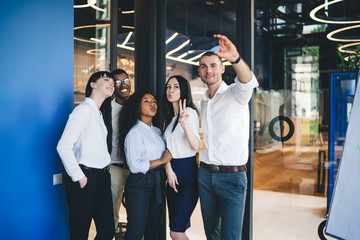 Obraz premium Playful staff taking selfie at workplace