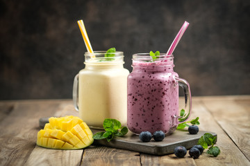 Delicious blueberry and mango smoothie in mason jar on a rustic background. Healthy food, detox...
