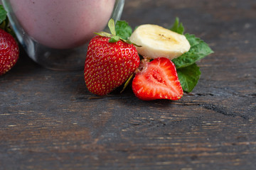 strawberry and banana healthy smoothie with fresh strawberrys in glass decorated with mint.