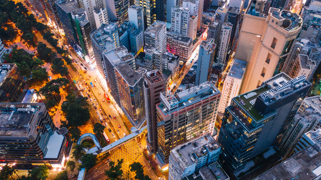 Aerial Top View Of Downtown District  Buildings In Night City Light. Bird's Eye View From Drone Of Cityscape Metropolis Infrastructure, Crossing Streets With Parked Cars. Development Infrastructure