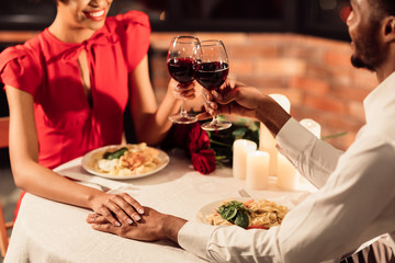 Unrecognizable Afro Lovers Clinking Glasses Holding Hands In Restaurant, Cropped