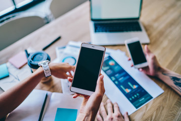 Colleagues browsing smartphones in modern office
