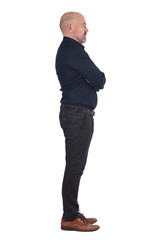 full portrait of a man from profile on white, arms crossed, profile