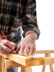 Close-up. Carpenter with pencil and the meter marks the measurement on a wooden board. Construction industry. White background.