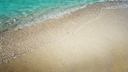 Fototapeta na wymiar Beautiful sand and soft blue wave of the sea. Summer beach background.