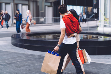 Couple embracing with paper bags in hands