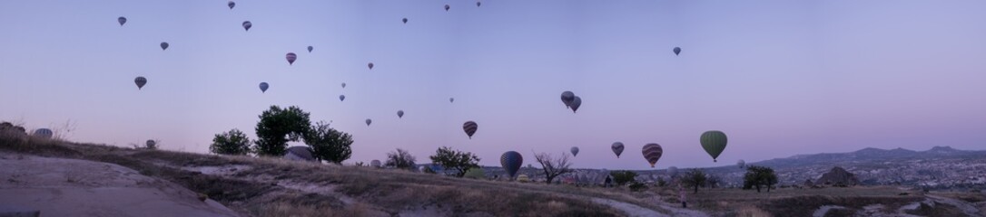 Cappadocia, Turkey, Europe: traditional hot air balloons floating at dawn in the sky over the valley of Cavusin in the historical region in Central Anatolia rich of exceptional natural wonders