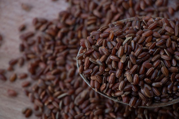 Wild rice, red and brown rice. on a wooden board. Wooden spoon on a white background. Healthy food, breakfast.