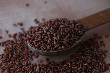 Wild rice, red and brown rice. on a wooden board. Wooden spoon on a white background. Healthy food, breakfast.