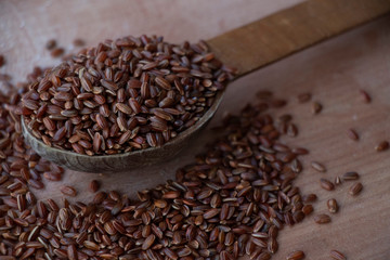 Wild rice, red and brown rice. on a wooden board. Wooden spoon on a white background. Healthy food,...