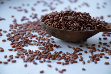 Wild rice, red and brown rice. on a wooden board. Wooden spoon on a white background. Healthy food,...