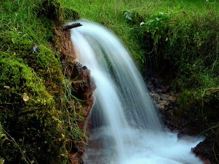 Soft waters running on rocks. Close-up of running water as a picture background