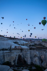 Cappadocia, Turkey, Europe: hot air balloons floating at dawn and view of the valley around Cavusin, town of the historical region in Central Anatolia rich of exceptional natural wonders