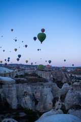 Cappadocia, Turkey, Europe: hot air balloons floating at dawn and view of the valley around Cavusin, town of the historical region in Central Anatolia rich of exceptional natural wonders