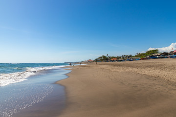 Fototapeta premium Berawa beach (Pantai Berawa) in Canggu. Wide sandy beach in sunny day. Bali island, Indonesia