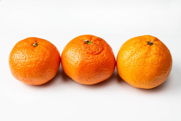 Three tangerines on a white background close-up