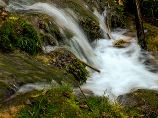 Soft waters running on rocks. Close-up of running water as a picture background