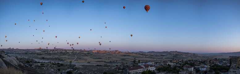 Cappadocia, Turkey, Europe: hot air balloons floating at dawn and view of the valley around Cavusin, town of the historical region in Central Anatolia rich of exceptional natural wonders