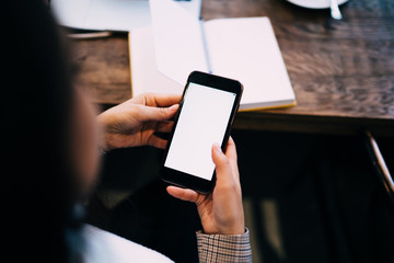 Woman surfing on smartphone in cafe