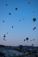 Cappadocia, Turkey, Europe: hot air balloons floating at dawn and view of the valley around Cavusin, town of the historical region in Central Anatolia rich of exceptional natural wonders