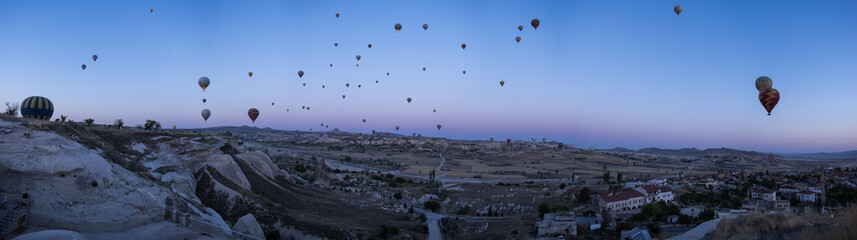 Cappadocia, Turkey, Europe: hot air balloons floating at dawn and view of the valley around Cavusin, town of the historical region in Central Anatolia rich of exceptional natural wonders