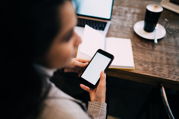 Lady texting on cellphone sitting at table