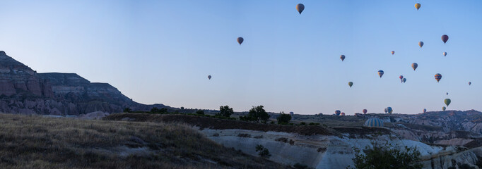 Cappadocia, Turkey, Europe: traditional hot air balloons floating at dawn in the sky over the valley of Cavusin in the historical region in Central Anatolia rich of exceptional natural wonders
