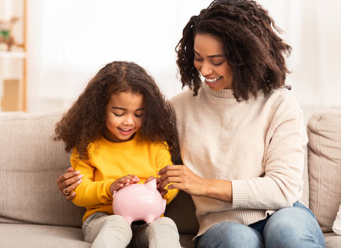 Cheerful Mother Teaching Daughter How To Save Money At Home