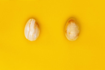 Yellow stone Easter eggs close up. Minimal style composition with Easter design concept. Pastel colors and paper background. Top view.